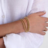 A woman’s arm wearing a Luxe Bubble Bracelet Set with a white linen shirt. 