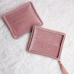 Two pink velvet jewelry boxes with a Pavé Madre Necklace on a textured off-white background. 