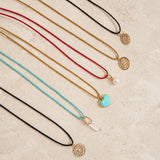 Set of necklaces with various Color Cored Necklaces with pendants on a textured surface