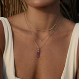 Model wearing the Element Short Link Chain with a Balance Crystal Charm and layered diamond necklaces.