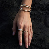 Model wearing the Lily Bouquet Bracelet layered with gold and diamond bracelets.