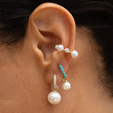 Close-up of Maya Brenner Orbit Pearl Ear Cuff worn in an ear stack with turquoise huggie hoops and pearl earring charms, no piercing ear cuff