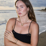 Model wearing the Maya Brenner Mini Pearl Ear Charm on Soleil Hoops with layered pearl earrings.