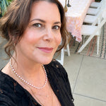Maya Brenner wearing the Cabana Pearl Necklace layered with delicate gold necklaces at an outdoor gathering