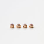 Four rose gold moonstone birthstone charms on a white background. 