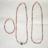 Endless Summer Necklaces in Coral Reef and Sweet Escape and an Endless Summer Bracelet in Coral Reef on a cream fabric background.