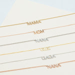 A Pavé MAMA Necklace in yellow gold, a MOM Necklace in rose gold, a Pavé NANA Necklace in white gold, a GIGI Necklace in yellow gold, a Pavé GAGA Necklace in white gold and a Pavé NANA Necklace in rose gold, against an off-white background. 