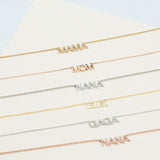 A Pavé MAMA Necklace in yellow gold, a MOM Necklace in rose gold, a Pavé NANA Necklace in white gold, a GIGI Necklace in yellow gold, a Pavé GAGA Necklace in white gold and a Pavé NANA Necklace in rose gold, against an off-white background. 