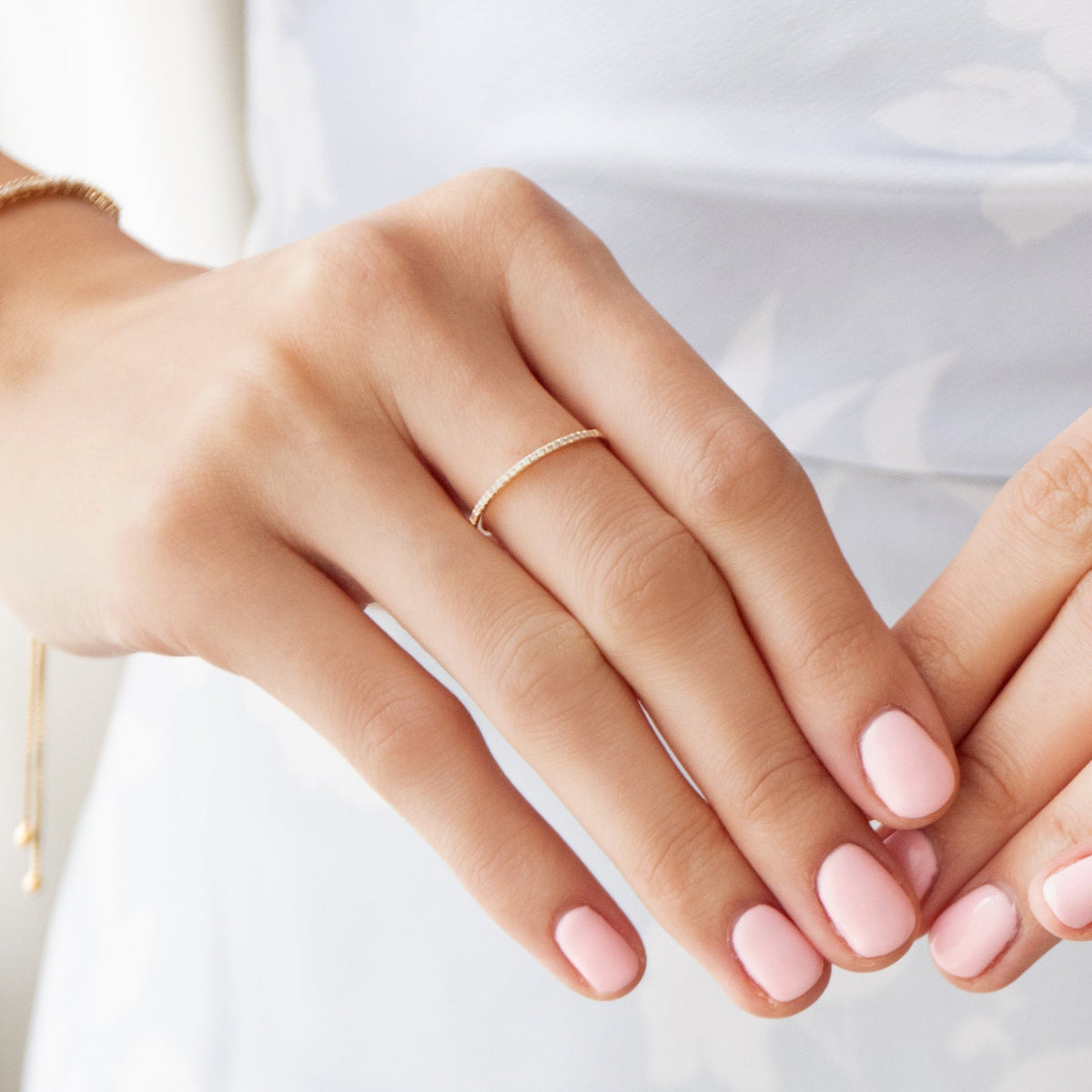 Close-up of a hand wearing a Pavé Diamond Ring with light pink nails, against a light background.