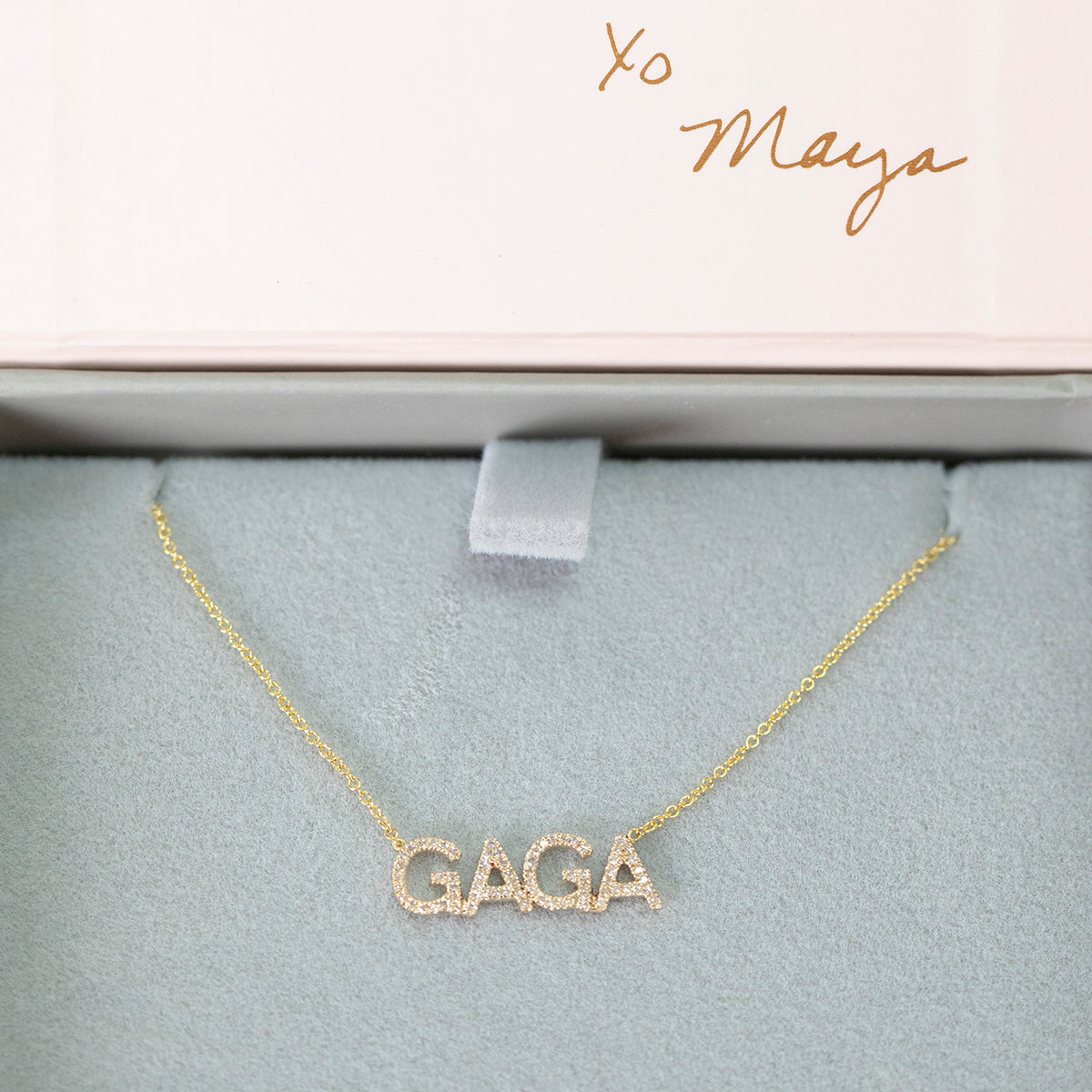 A Pavé GAGA Necklace in yellow gold with a cable chain in a Maya Brenner light grey and pink jewelry box. 