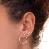 Close-up of an ear wearing a Birthstone Stud - Moonstone (June), 14K Gold Pavé Letter Stud in C and a Mini Preppy Post with a Circle Ear Jacket Pave, against a white blurred background. 
