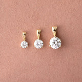 A Duchess Diamond Pendant, Princess Diamond Pendant and Queen Diamond Pendant against a dusty rose color. 