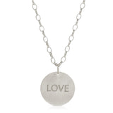The back of a Virtues Pendant - Circle in sterling silver with 'LOVE' engraved on a white background. 
