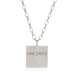 The back of a Virtues Pendant - Square in sterling silver with 'SINCERITY' engraved on a white background. 