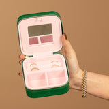 A Travel Jewelry Case - Green/Pink on a light brown background. 
