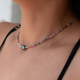 A close-up of a neck wearing an Endless Summer Bracelet - Sweet Escape, styled with a black strap top. 