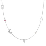 A Custom Gold Necklace in white gold with six charms, the letters R and D, two birthstones, a pavé moon and an angel wing, on a white background.