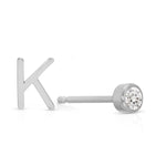 A white gold monogram earring set, featuring a mini letter K stud and a mini diamond stud on a white background. 