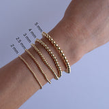 Yellow gold Bubble Bracelets  of different sizes on a wrist with size measurements.