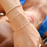 Close-up of a woman’s wrist wearing a yellow gold Doubles Cuff, an Off the Cuff Bracelet and a Love Set Match Bracelet.