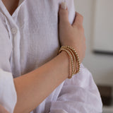 A woman's arm wearing the Statement Bubble Bracelet Set with a white linen shirt.