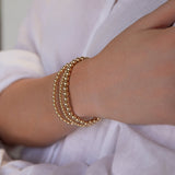 A woman's arm wearing the Statement Bubble Bracelet Set with a white linen shirt.