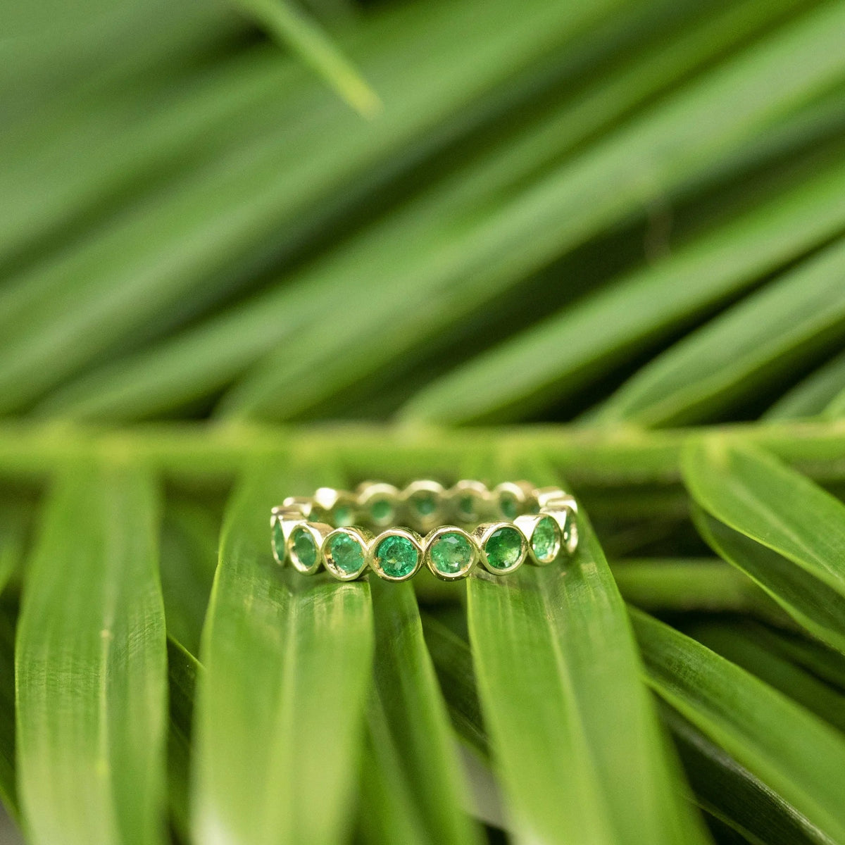 The Fern Bouquet Ring against a green leafy background. 