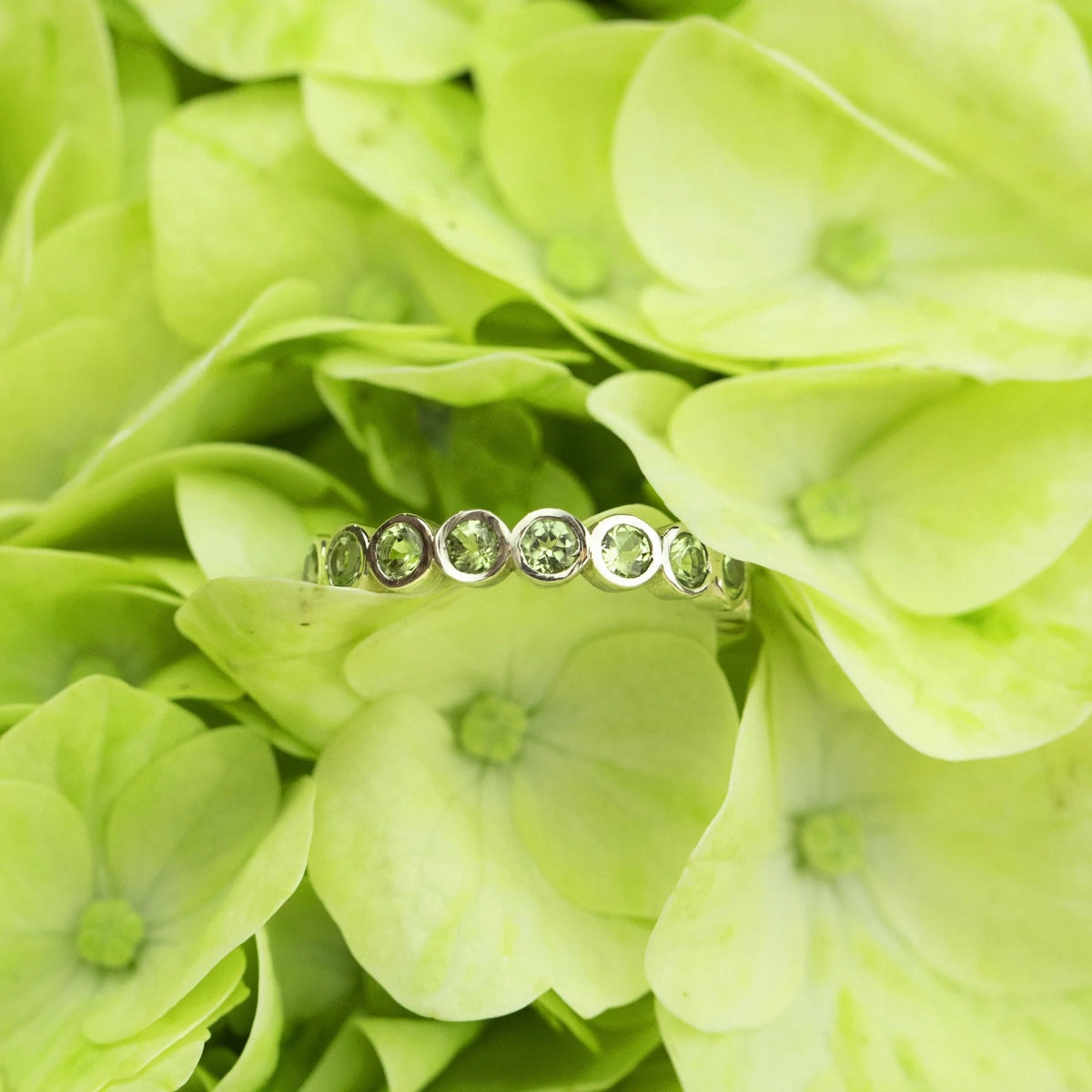 The Hydrangea Bouquet Ring on a green floral background. 
