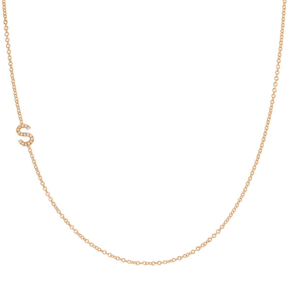 A rose gold necklace with a pave letter S charm on a white background. 