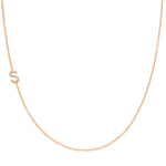 A rose gold necklace with a pave letter S charm on a white background. 