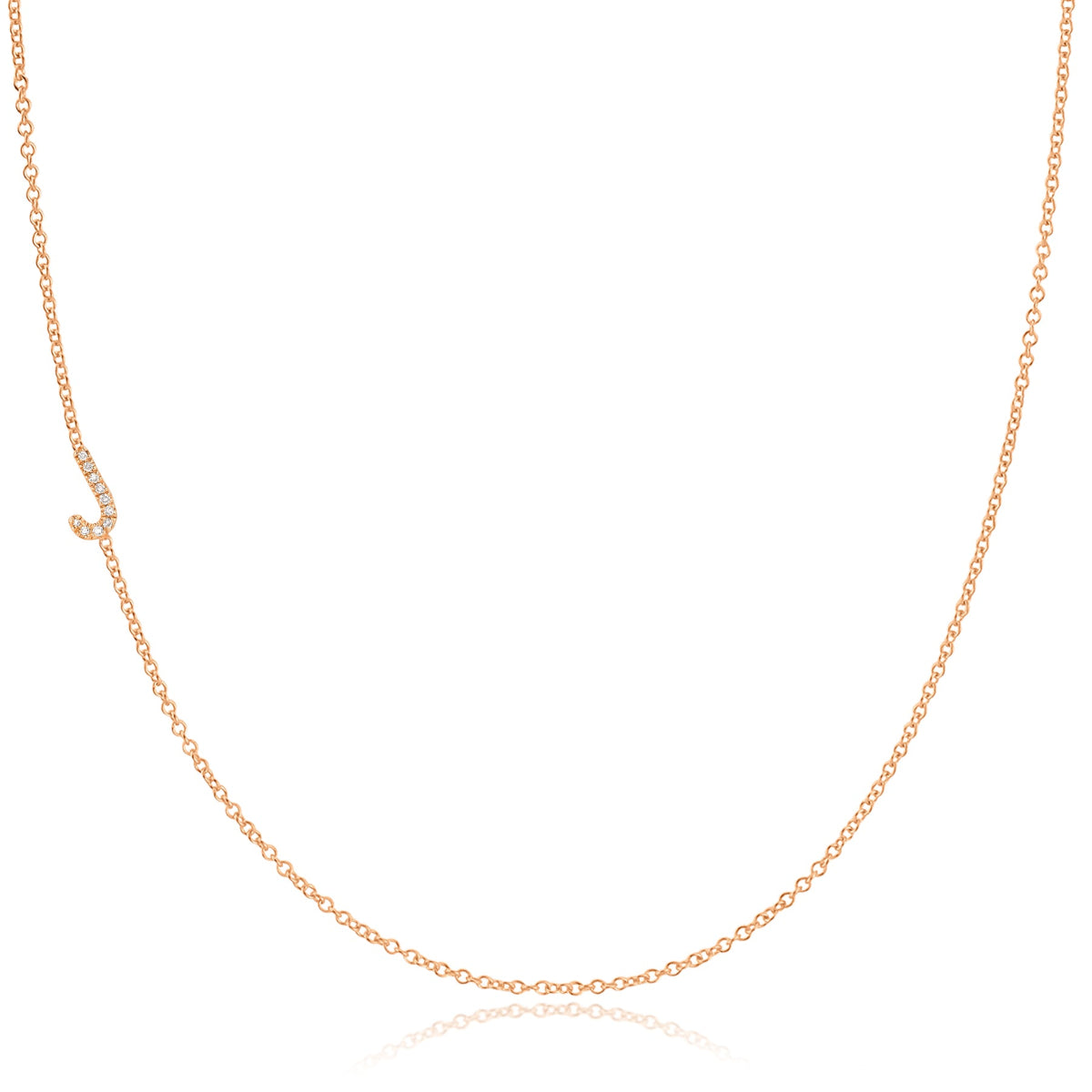 A rose gold necklace with a pave letter J charm on a white background. 