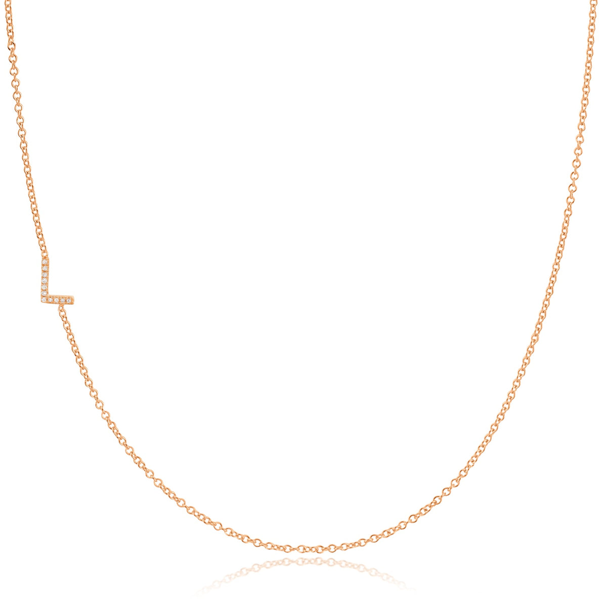 A rose gold necklace with a pave letter L charm on a white background. 