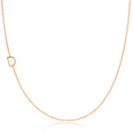A rose gold necklace with a D letter charm on a white background. 