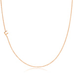 A rose gold necklace with a F letter charm on a white background. 