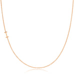 A rose gold necklace with an I letter charm on a white background. 