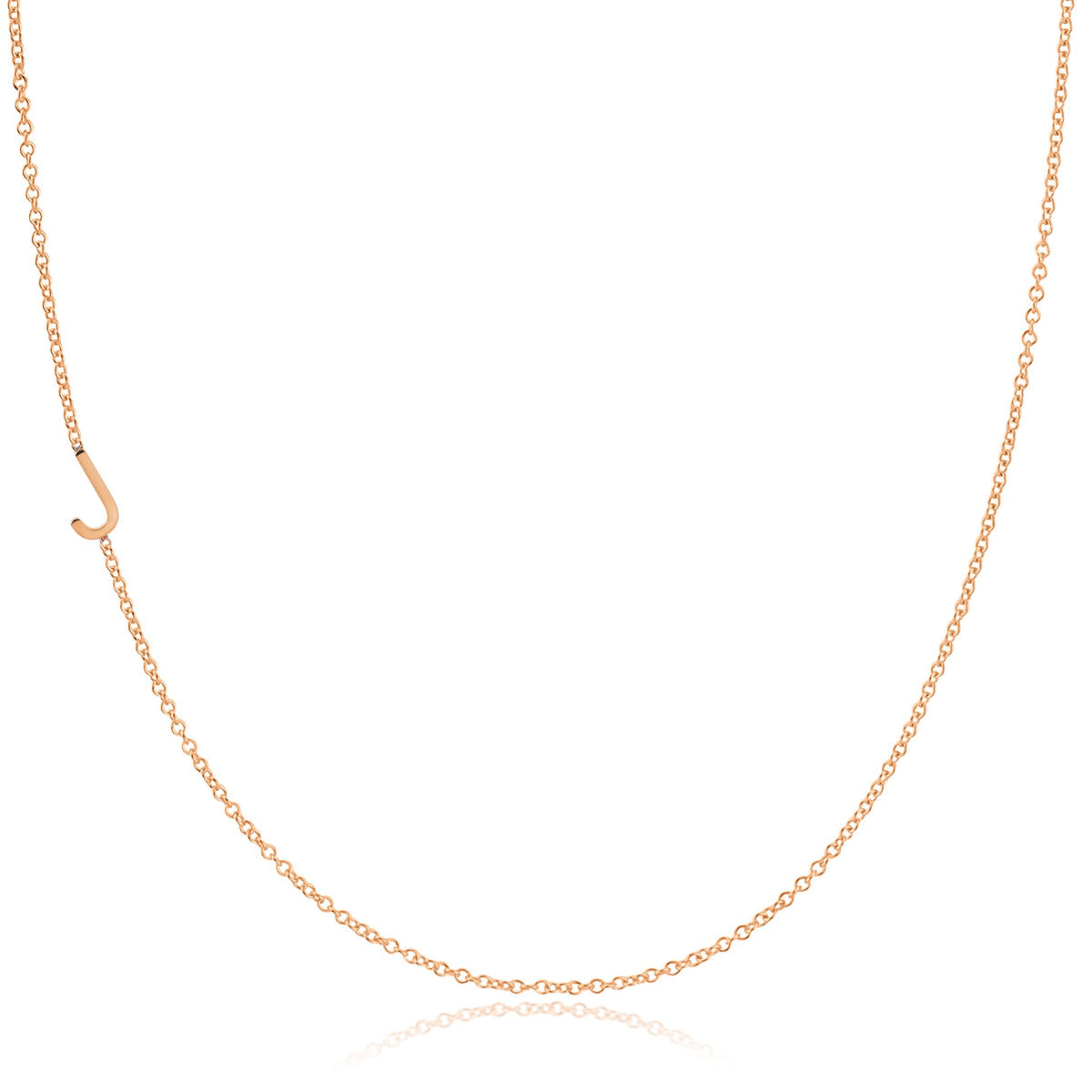 A rose gold necklace with a J letter charm on a white background. 