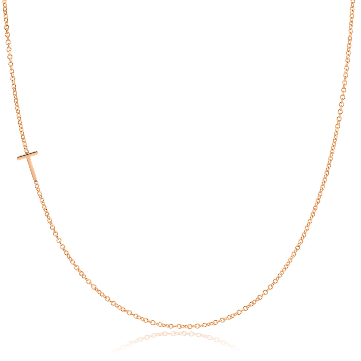 A rose gold necklace with a T letter charm on a white background. 