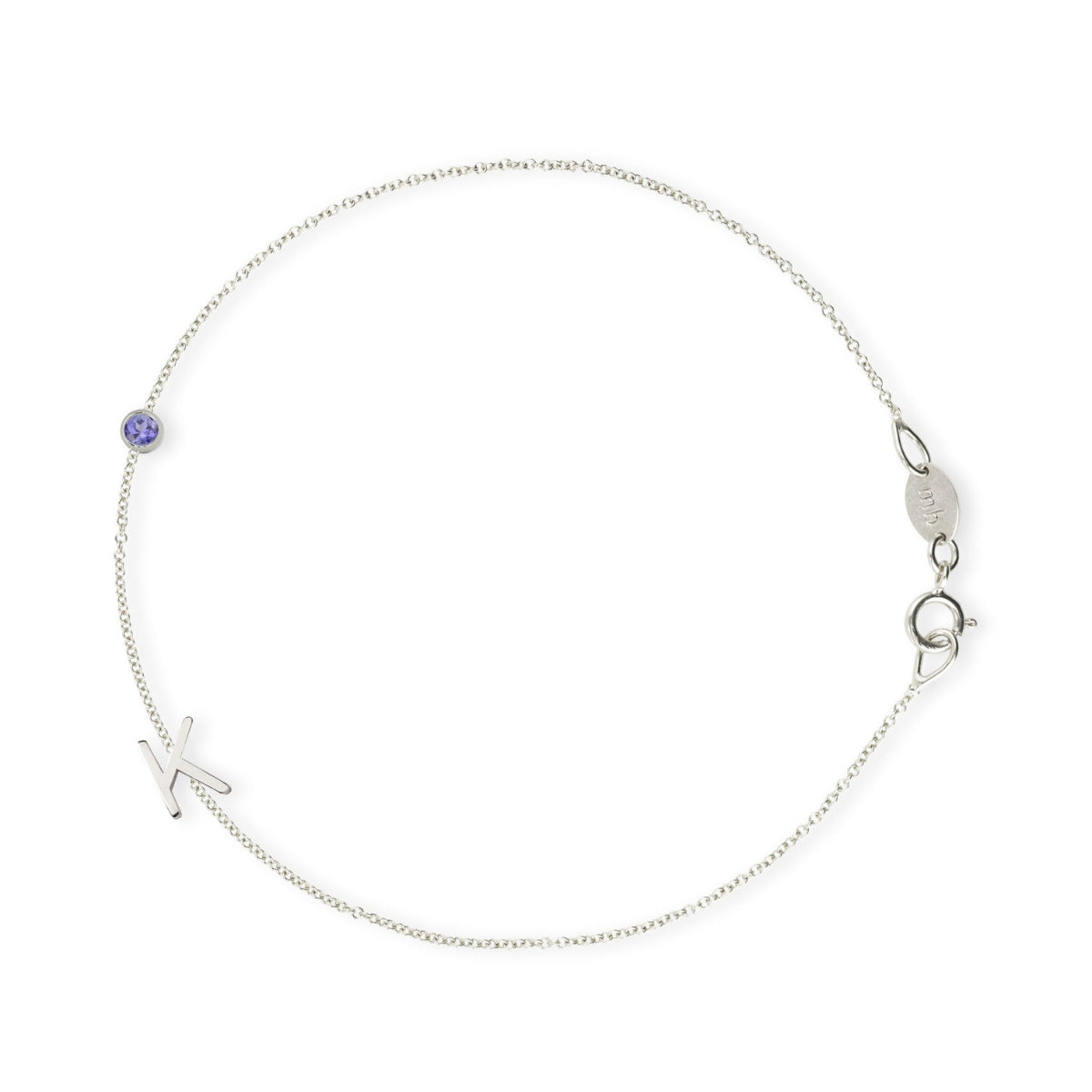 A white gold Custom Gold Bracelet - 2 Letters (a letter K charm and tanzanite birthstone) on a white background. 