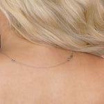 A white gold Chain Extender shown on the back of a neck with blonde hair. 