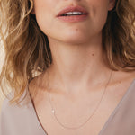 A white gold 14k Gold Asymmetrical Charm Necklace - Cross with a cable chain on a white background. 