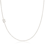 A white gold necklace with a B letter pave charm on a white background. 
