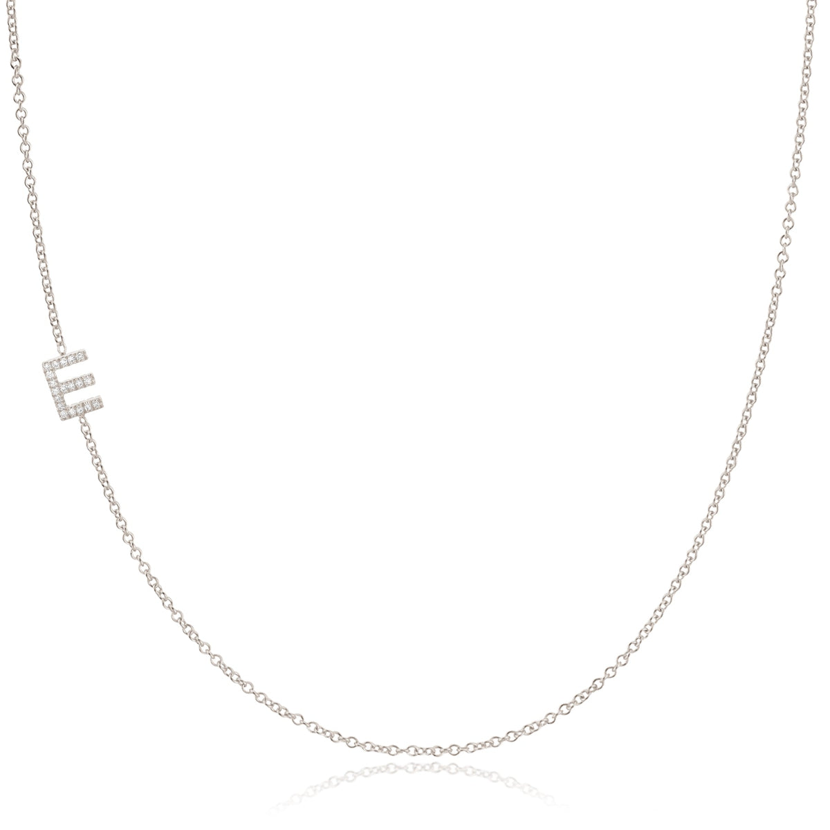 A white gold necklace with a E letter pave charm on a white background. 