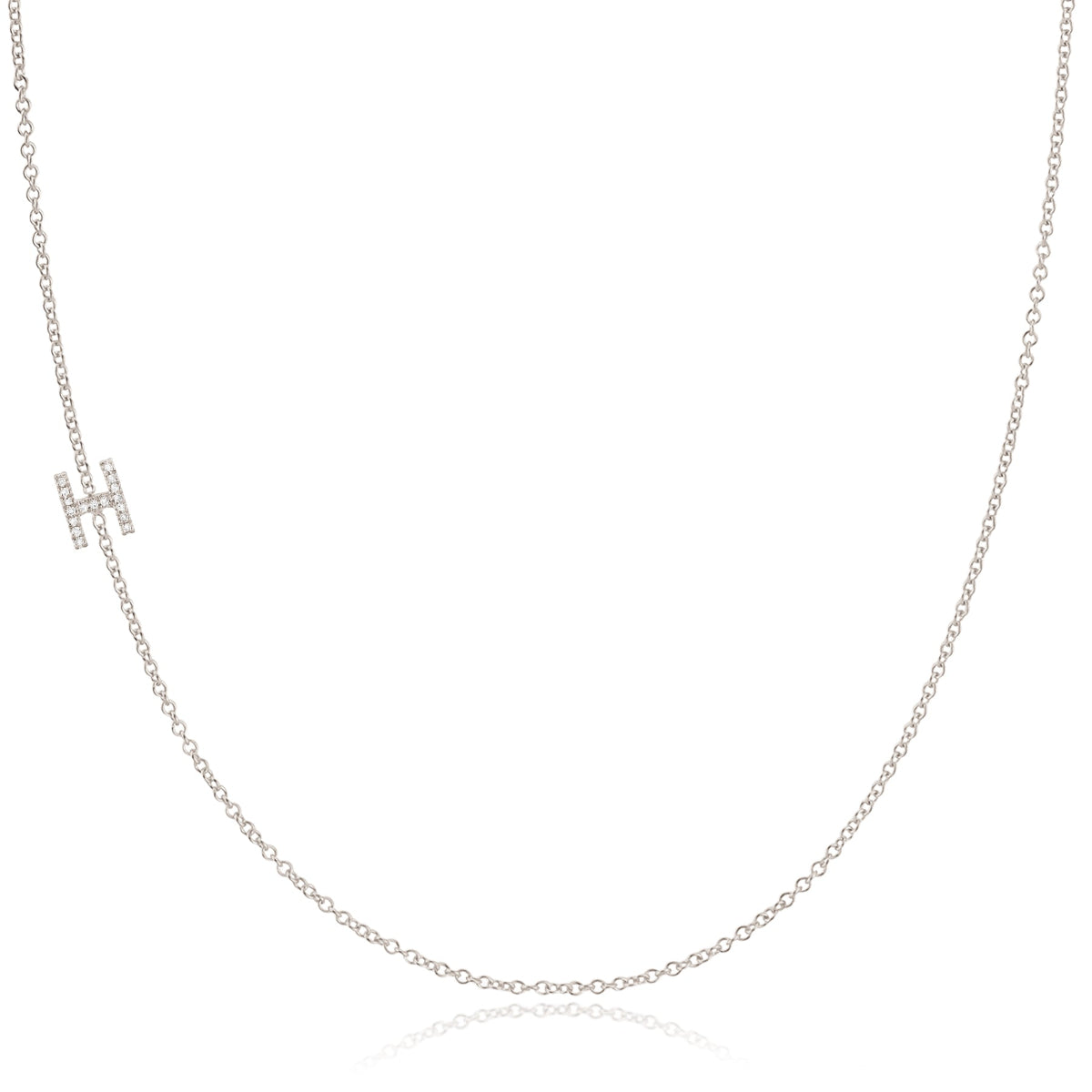 A white gold necklace with a H letter pave charm on a white background.