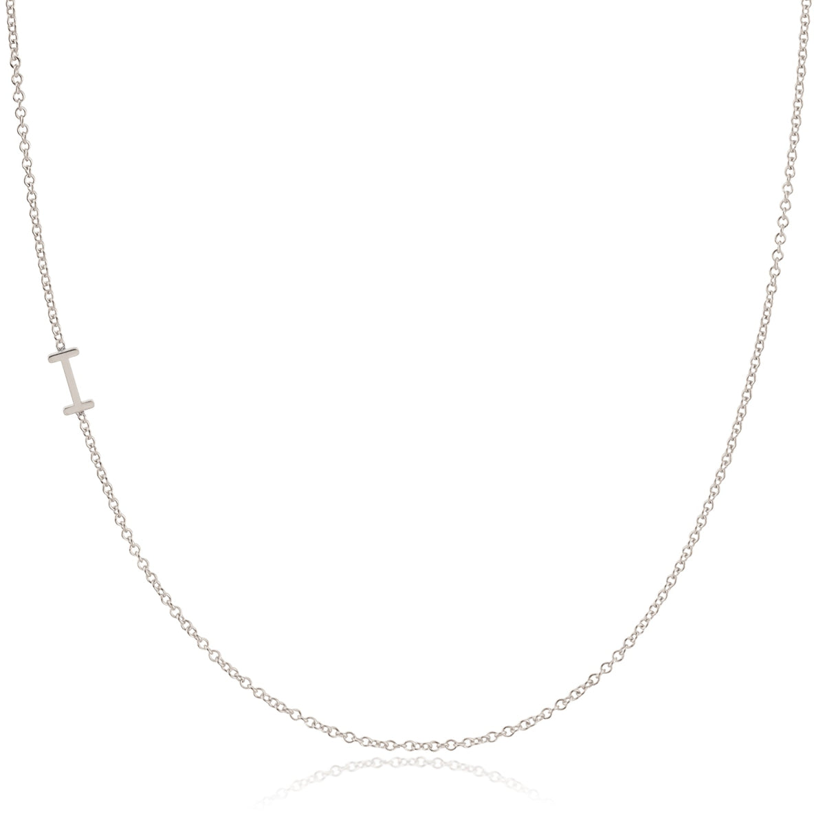 A white gold necklace with an I letter charm on a white background. 