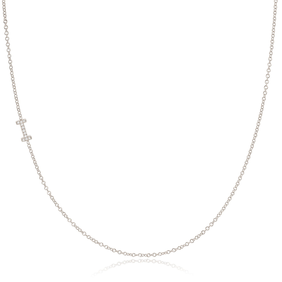 A white gold necklace with a letter I pave charm on a white background.