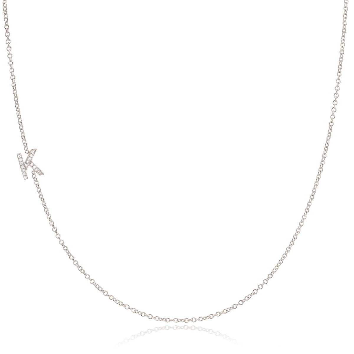 A white gold necklace with a letter K pave charm on a white background.