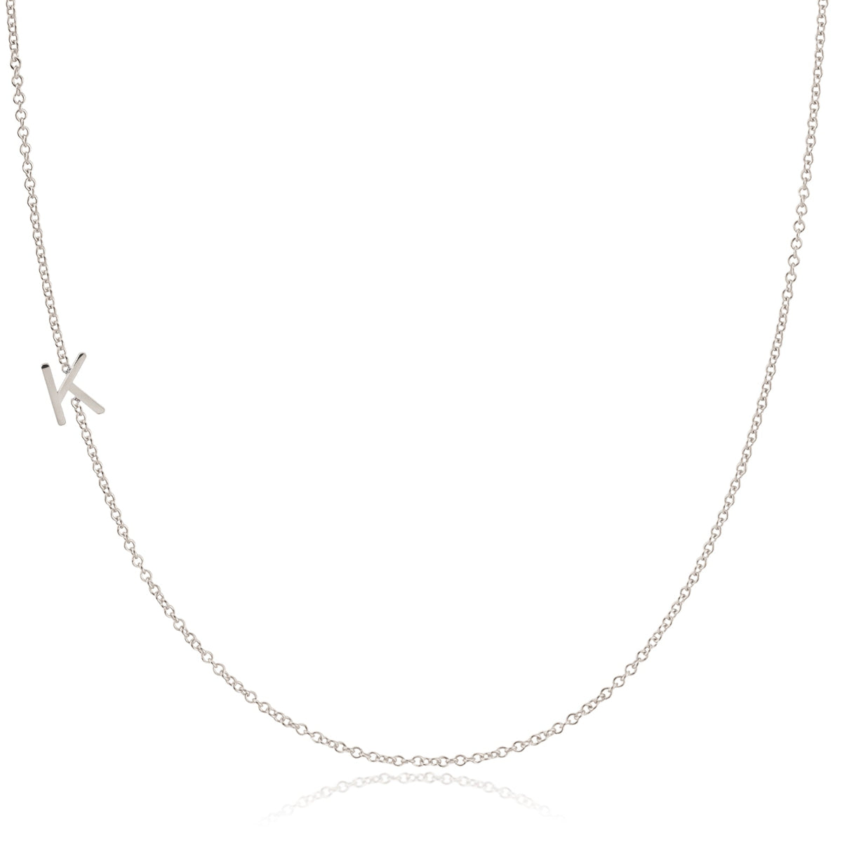 A white gold necklace with a K letter charm on a white background. 