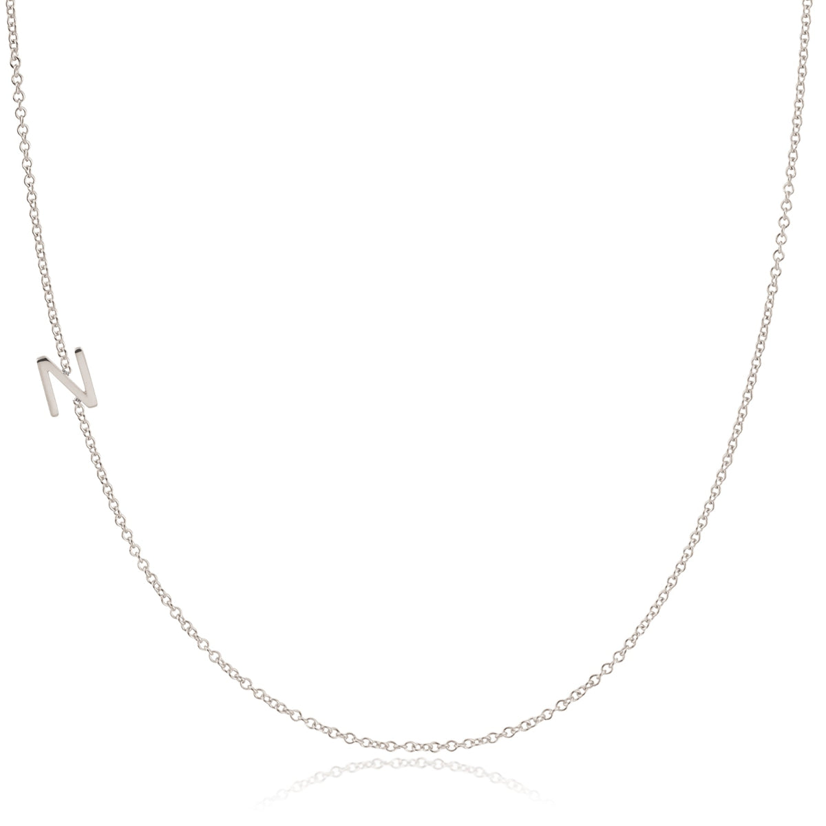 A white gold necklace with an N letter charm on a white background. 