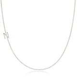 A white gold necklace with an N letter charm on a white background. 