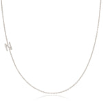 A white gold necklace with a letter N pave charm on a white background.